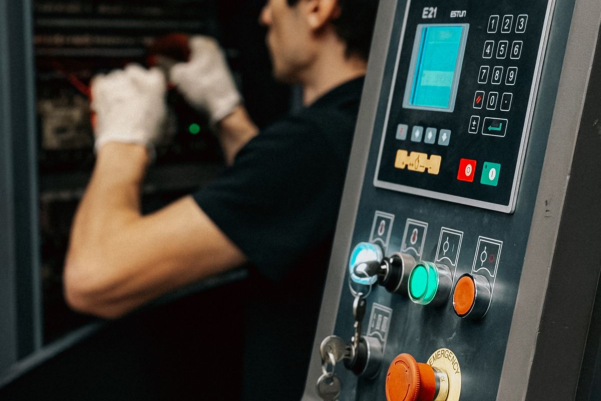 Technician servicing the control cabinet of an industrial press